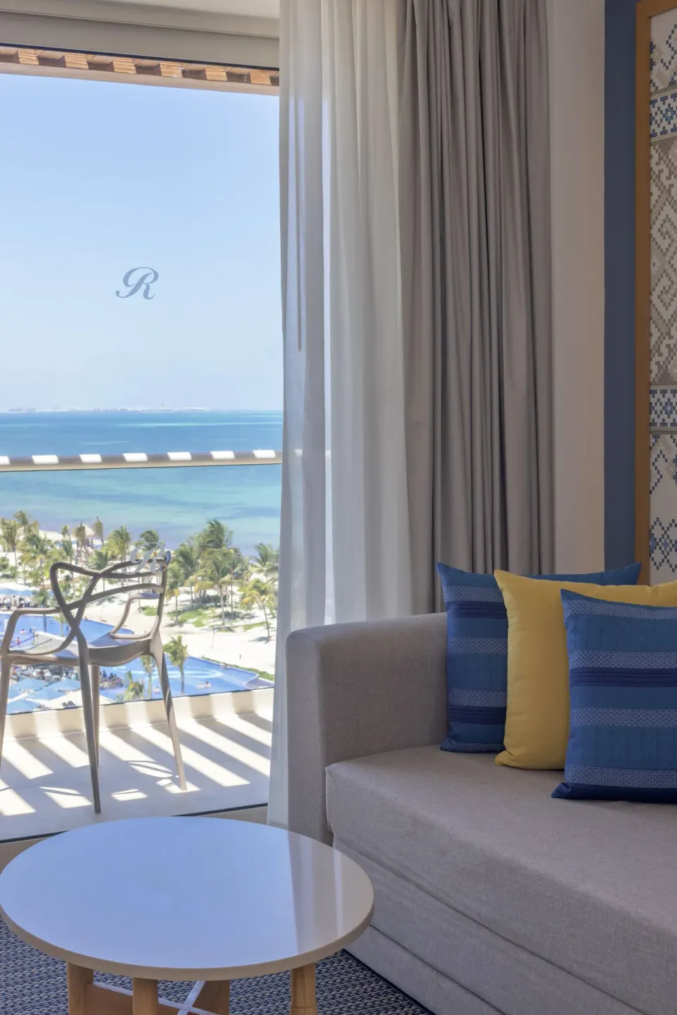 Sofa and balcony ocean view in a Luxury Junior Suite at Royalton Splash Riviera Cancun.