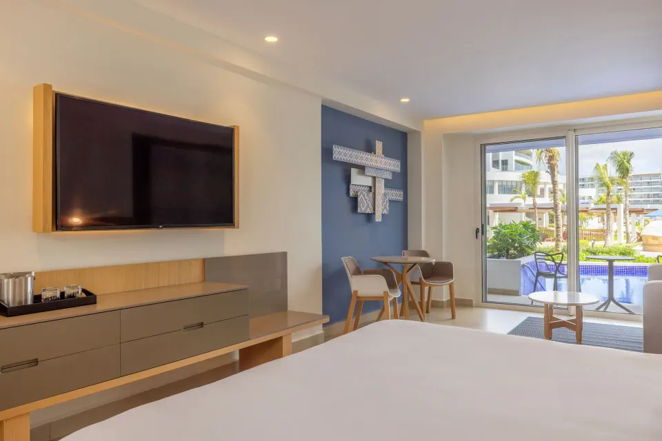 Luxury Junior Suite Swim Out king bed view toward patio at Royalton Splash Riviera Cancun.