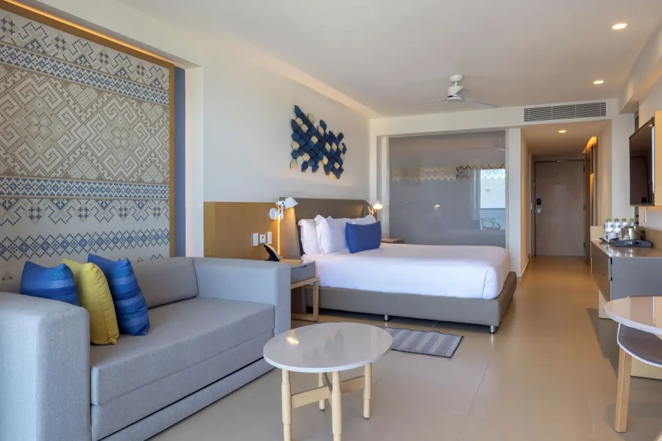 Luxury Junior Suite Swim Out king bed and sitting area at Royalton Splash Riviera Cancun.