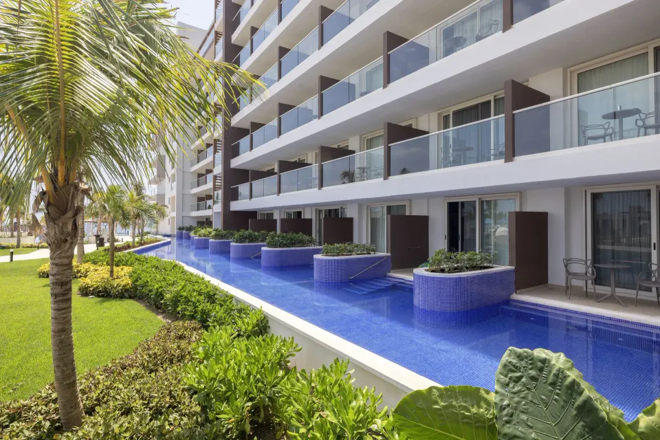 Luxury Junior Suite Swim Out rooms along a blue pool at Royalton Splash Riviera Cancun.