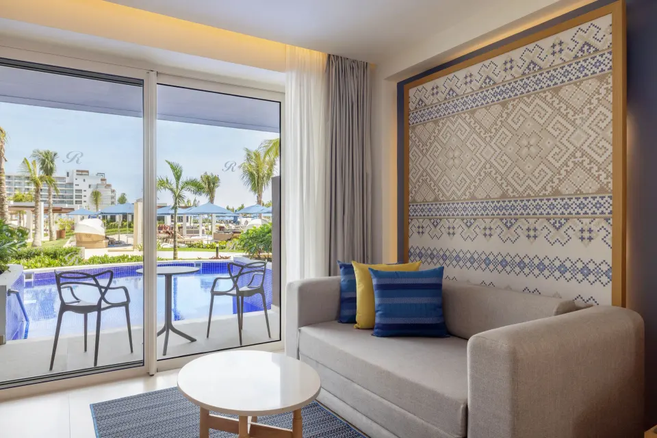 Luxury Junior Suite Swim Out sofa by sliding doors at Royalton Splash Riviera Cancun.