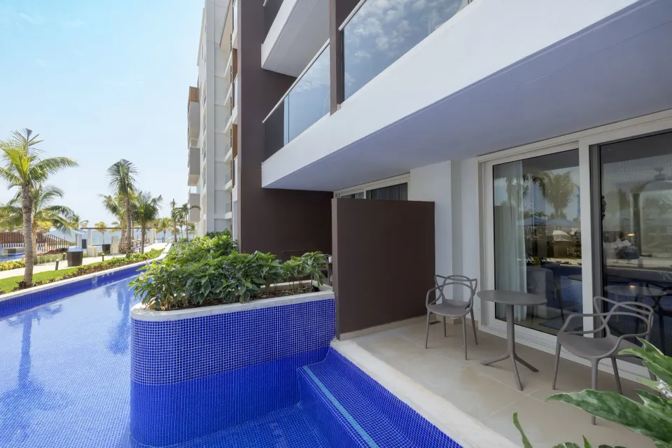 Luxury Junior Suite Swim Out terrace with table by pool at Royalton Splash Riviera Cancun.