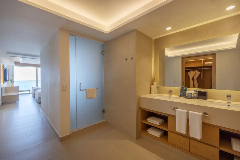 Luxury Junior Suite bathroom vanity with bedroom visible at Royalton Splash Riviera Cancun.