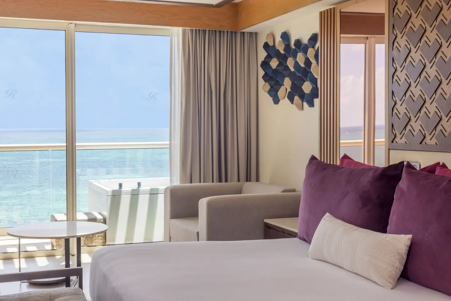 Oceanfront bedroom with balcony view in a suite at Royalton Splash Riviera Cancun.