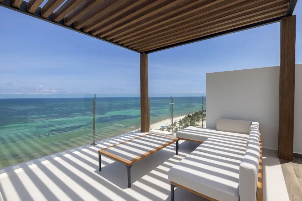 Ocean-view terrace sofa beneath a pergola at Royalton Splash Riviera Cancun.