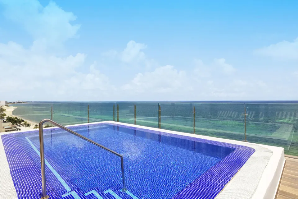 Blue-tiled terrace pool overlooking the ocean at Royalton Splash Riviera Cancun.