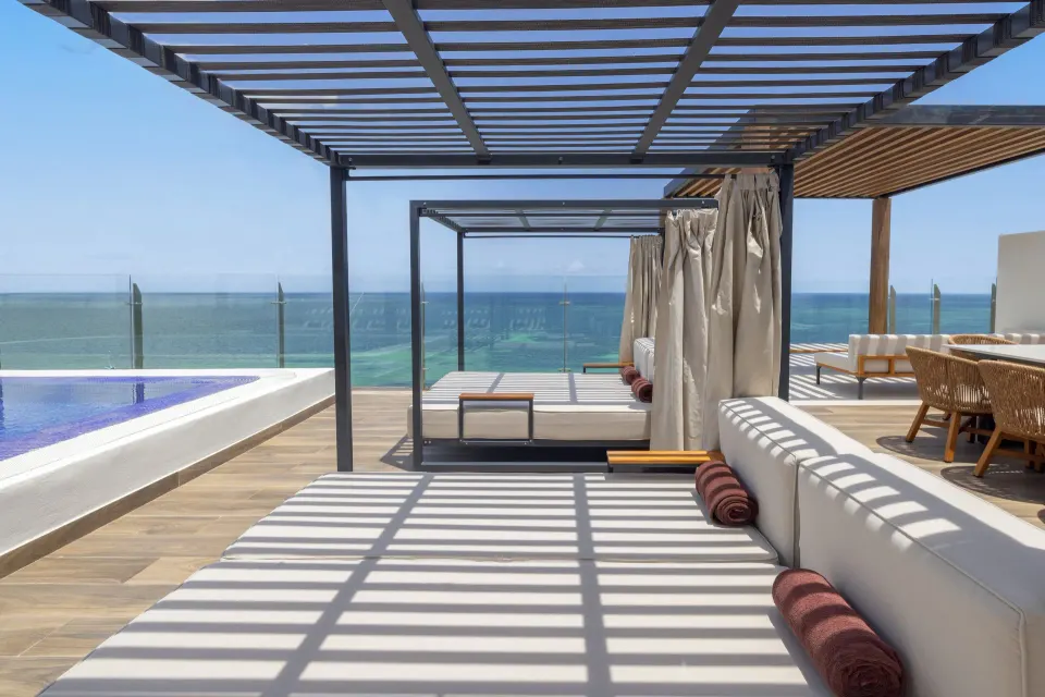 Terrace daybeds and pool edge facing the ocean at Royalton Splash Riviera Cancun.