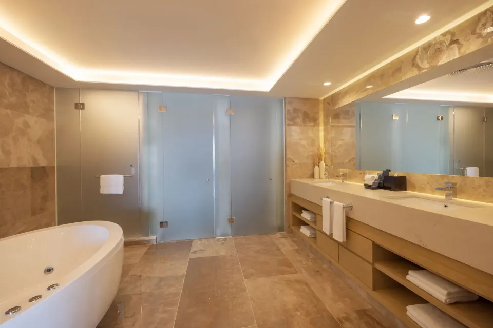 Suite bathroom with soaking tub, glass shower doors, and double vanity at Royalton Splash Riviera Cancun.