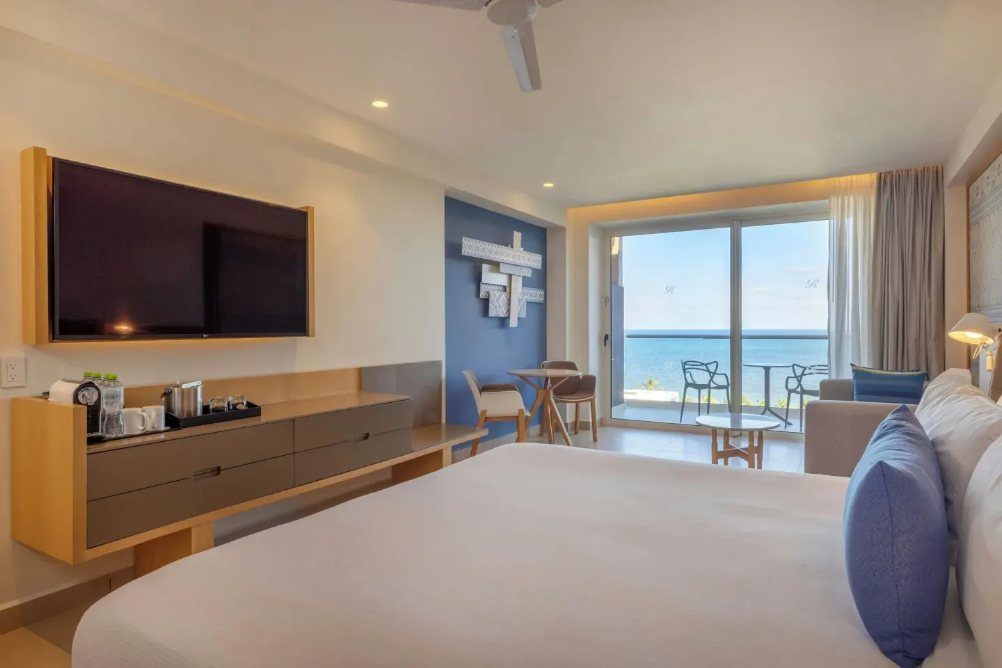 King bed suite with sofa, dining table, and oceanfront balcony at Royalton Splash Riviera Cancun.