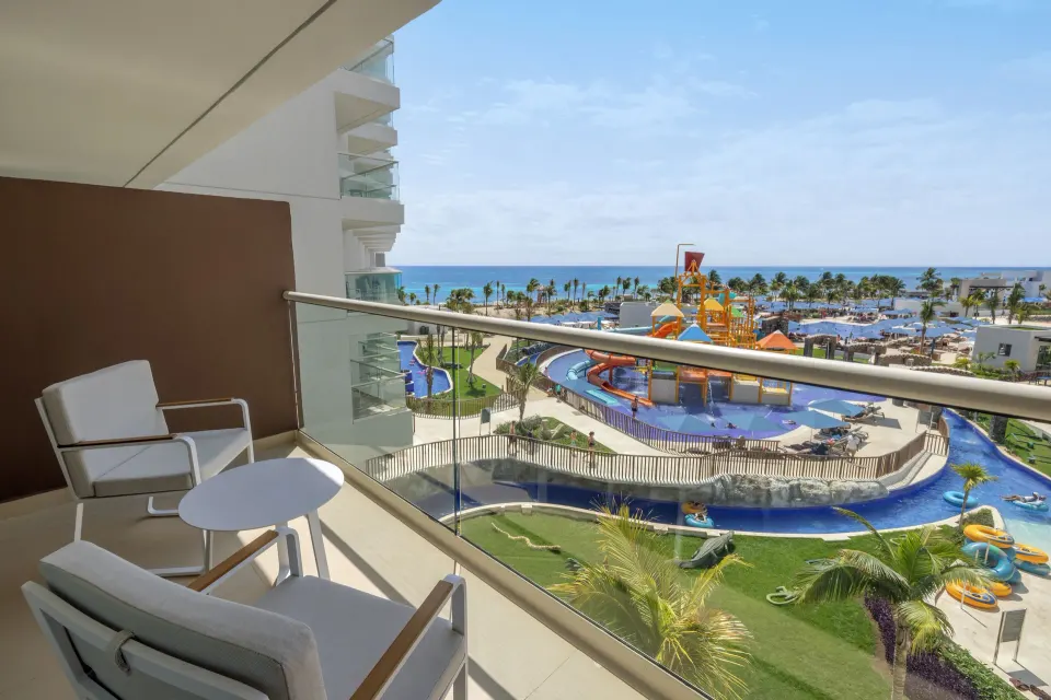 Furnished suite balcony with ocean and water park views at Royalton Splash Riviera Cancun.