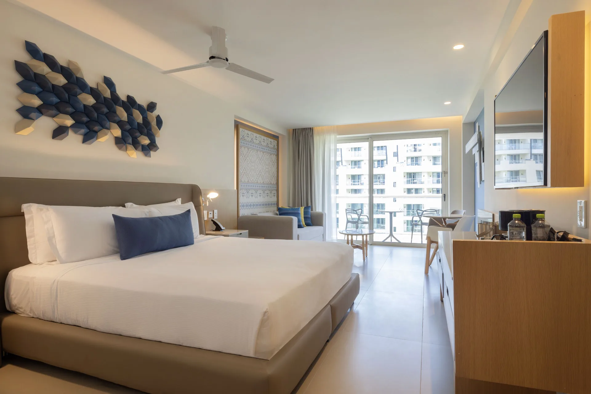 Two Bedroom Luxury Junior Suite king bed with balcony seating at Royalton Splash Riviera Cancun.