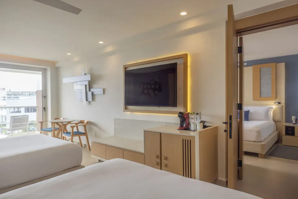 Two Bedroom Luxury Junior Suite with two beds, TV console and connecting bedroom at Royalton Splash Riviera Cancun.