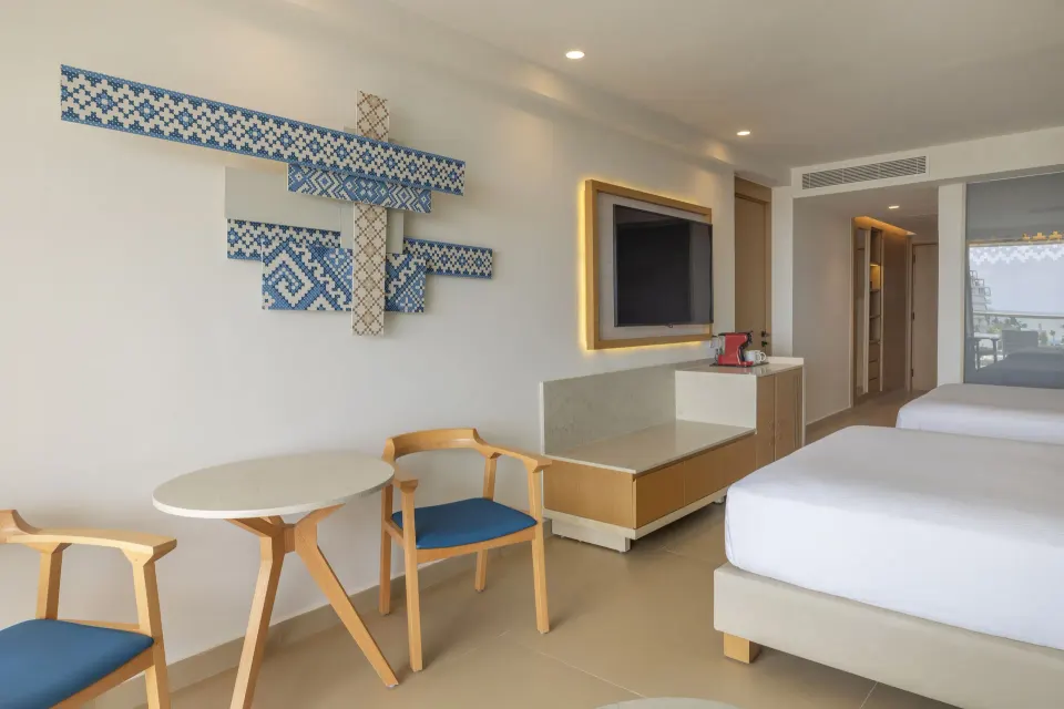Two Bedroom Luxury Junior Suite with twin beds and blue wall art at Royalton Splash Riviera Cancun.