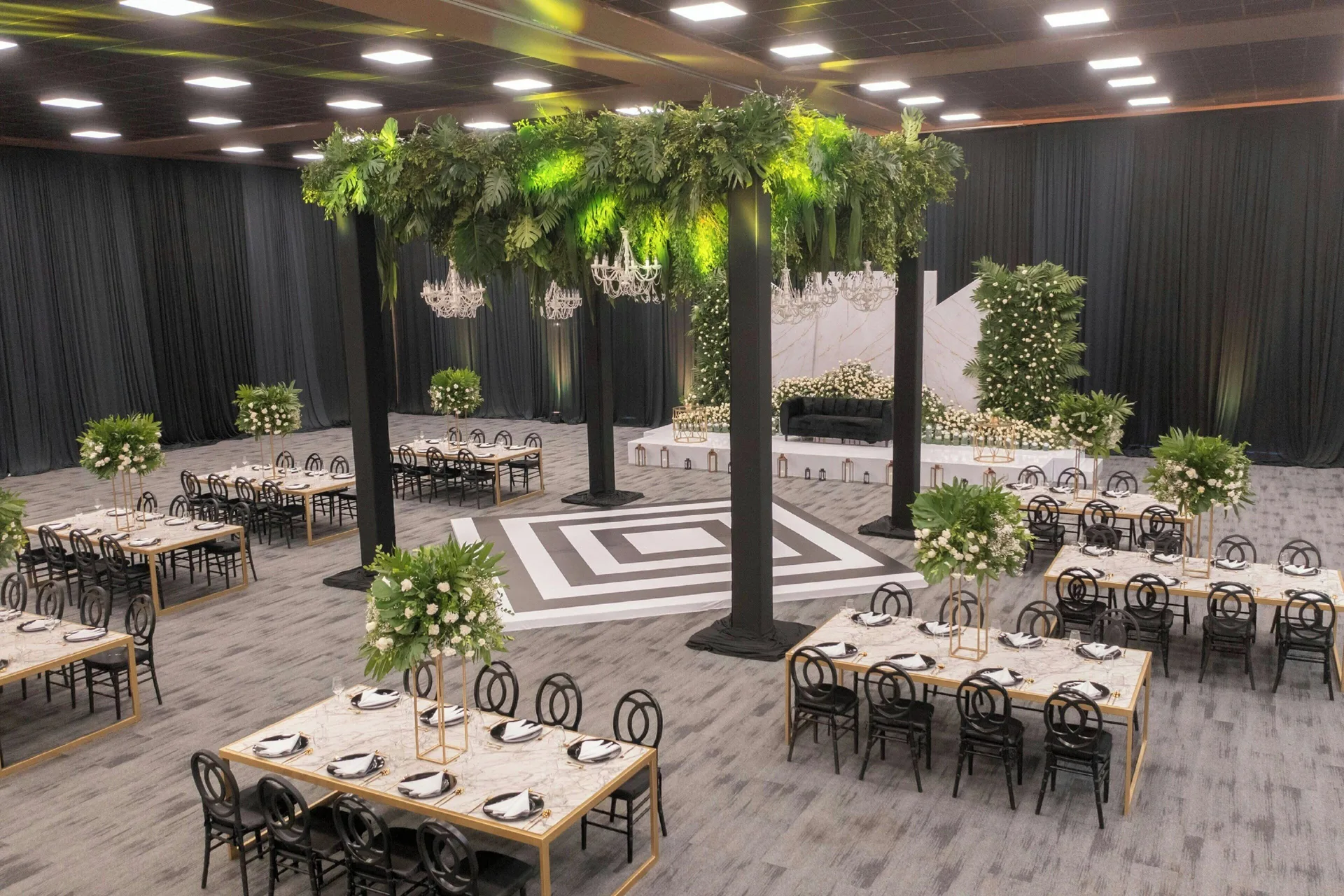 Indoor wedding reception with greenery and chandeliers at Royalton Splash Riviera Cancun.