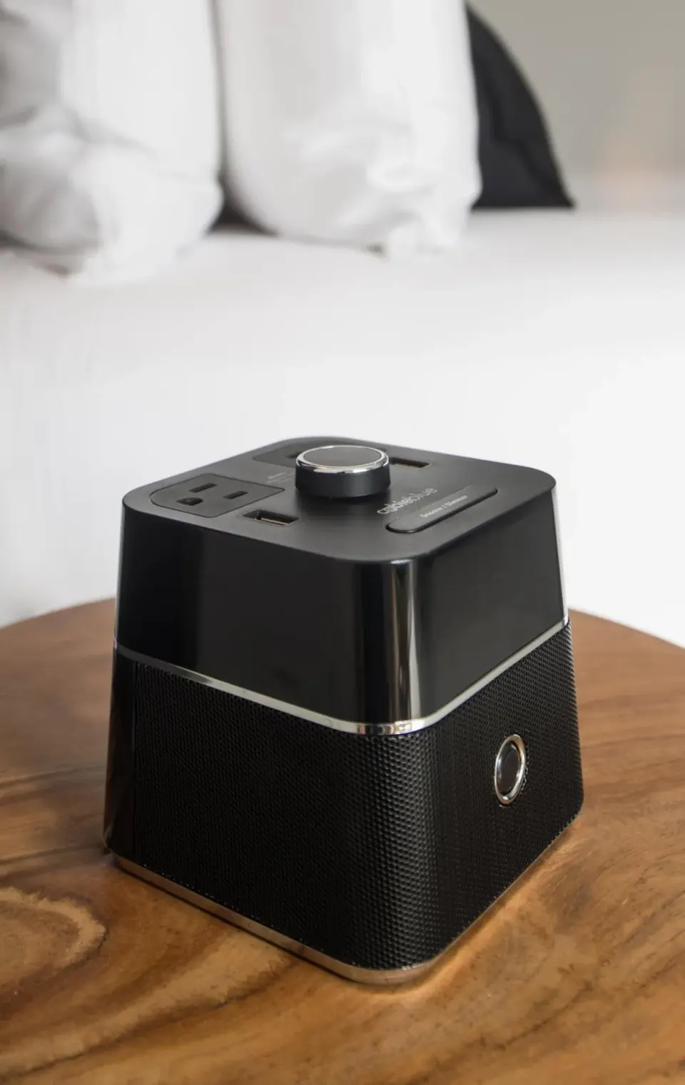 Bedside speaker and charging unit on a wooden table at S Hotel Montego Bay.