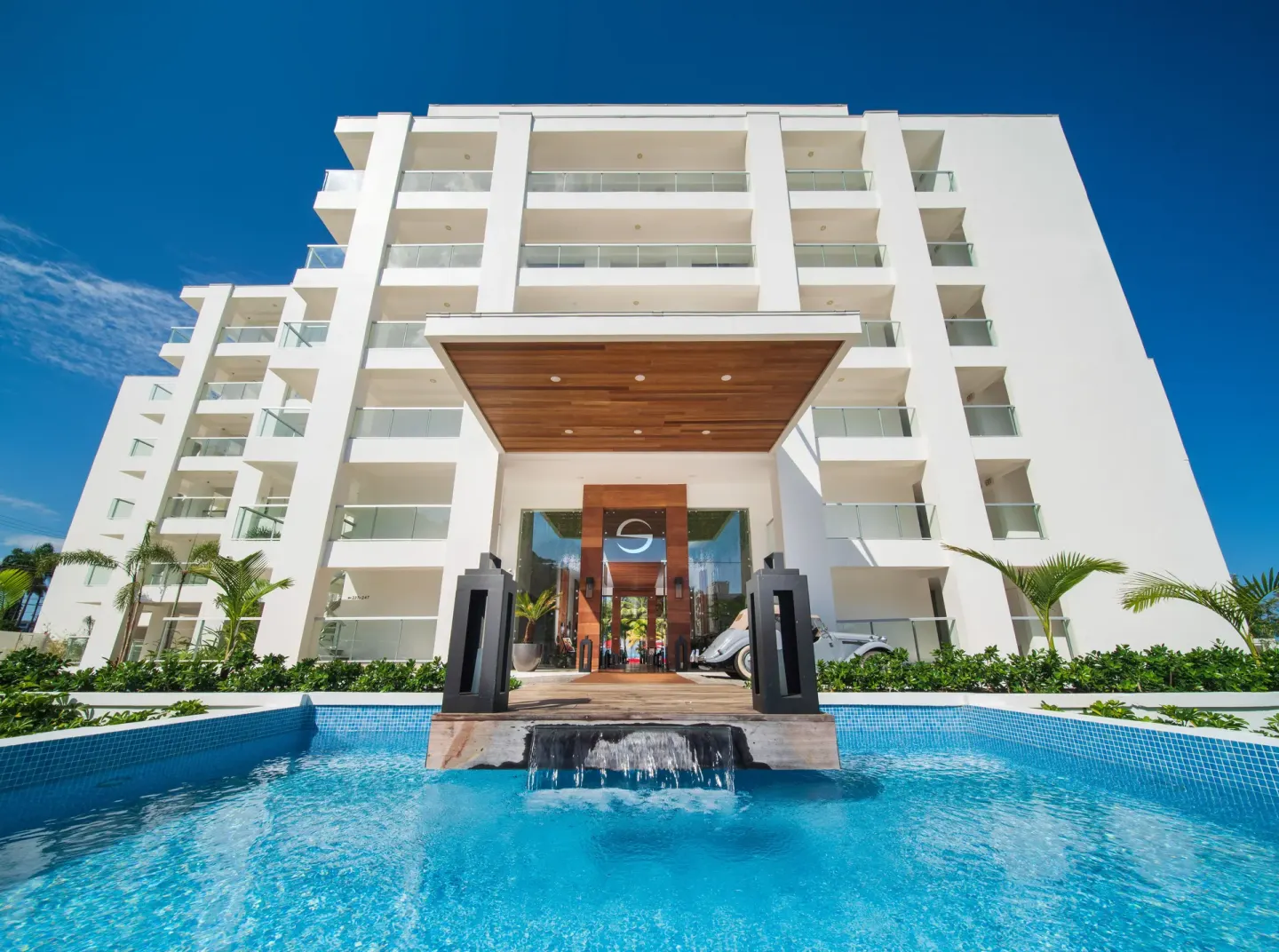 Front entrance, white balconies, and reflecting pool at S Hotel Montego Bay.