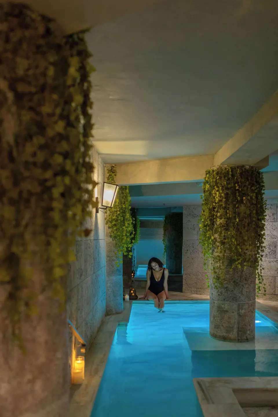 Indoor pool corridor with hanging greenery and candlelight at S Hotel Montego Bay.