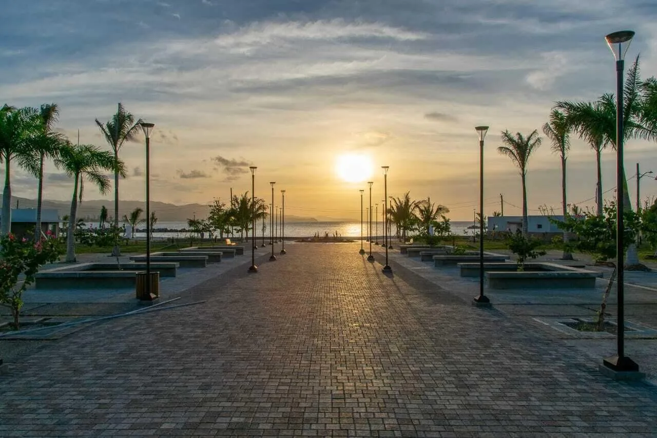 Sunset walkway lined with palms and lamps at S Hotel Montego Bay.