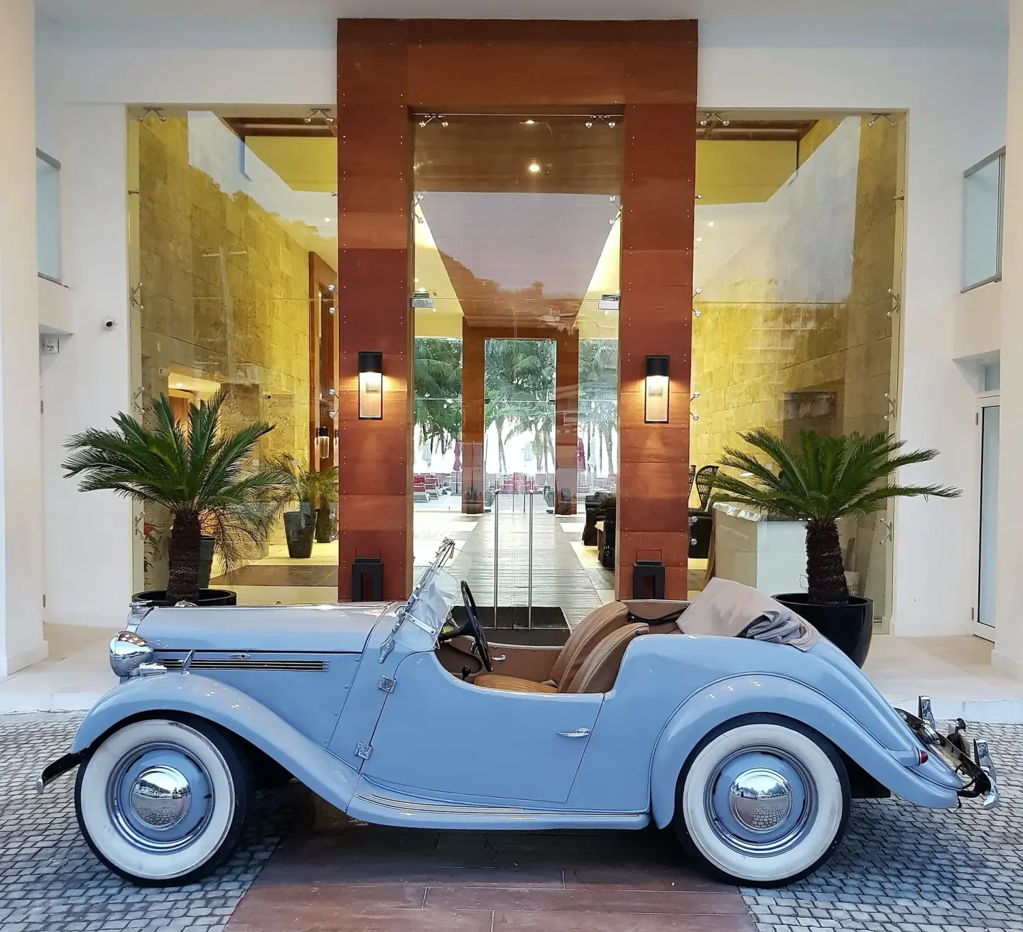 Vintage light blue convertible parked at the entrance of S Hotel Montego Bay.