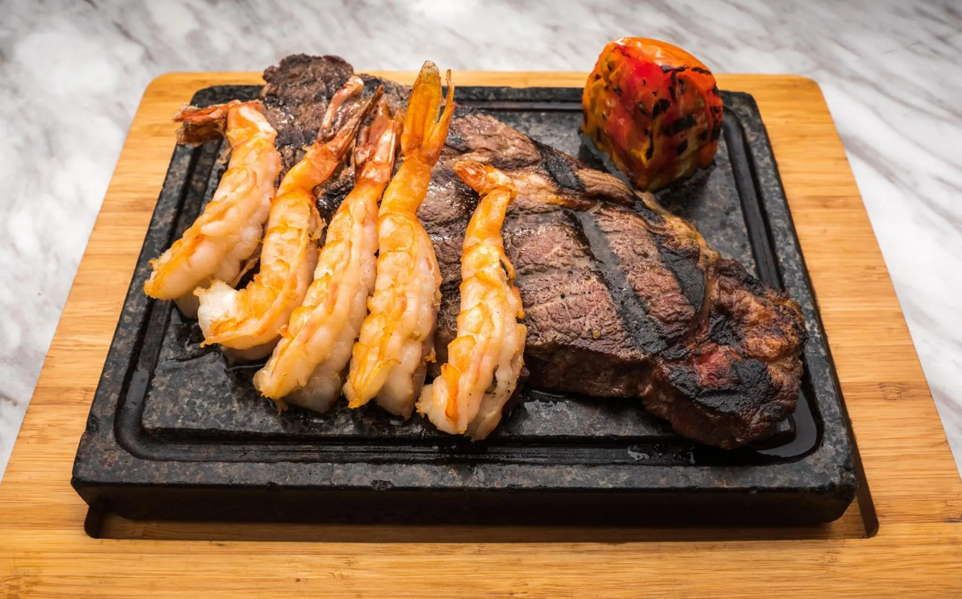 Grilled steak, shrimp, and a charred pepper served on a hot stone at S Hotel Montego Bay.