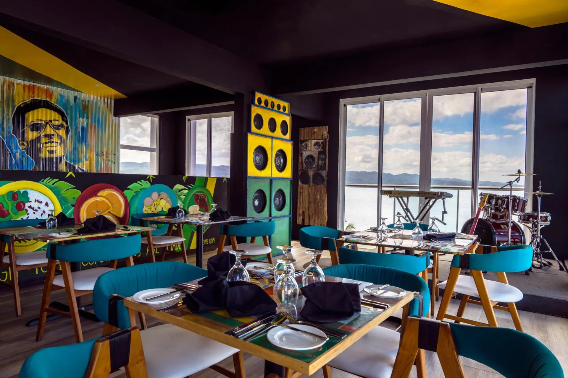 Colorful music-themed restaurant with stage and ocean-facing windows at S Hotel Montego Bay.