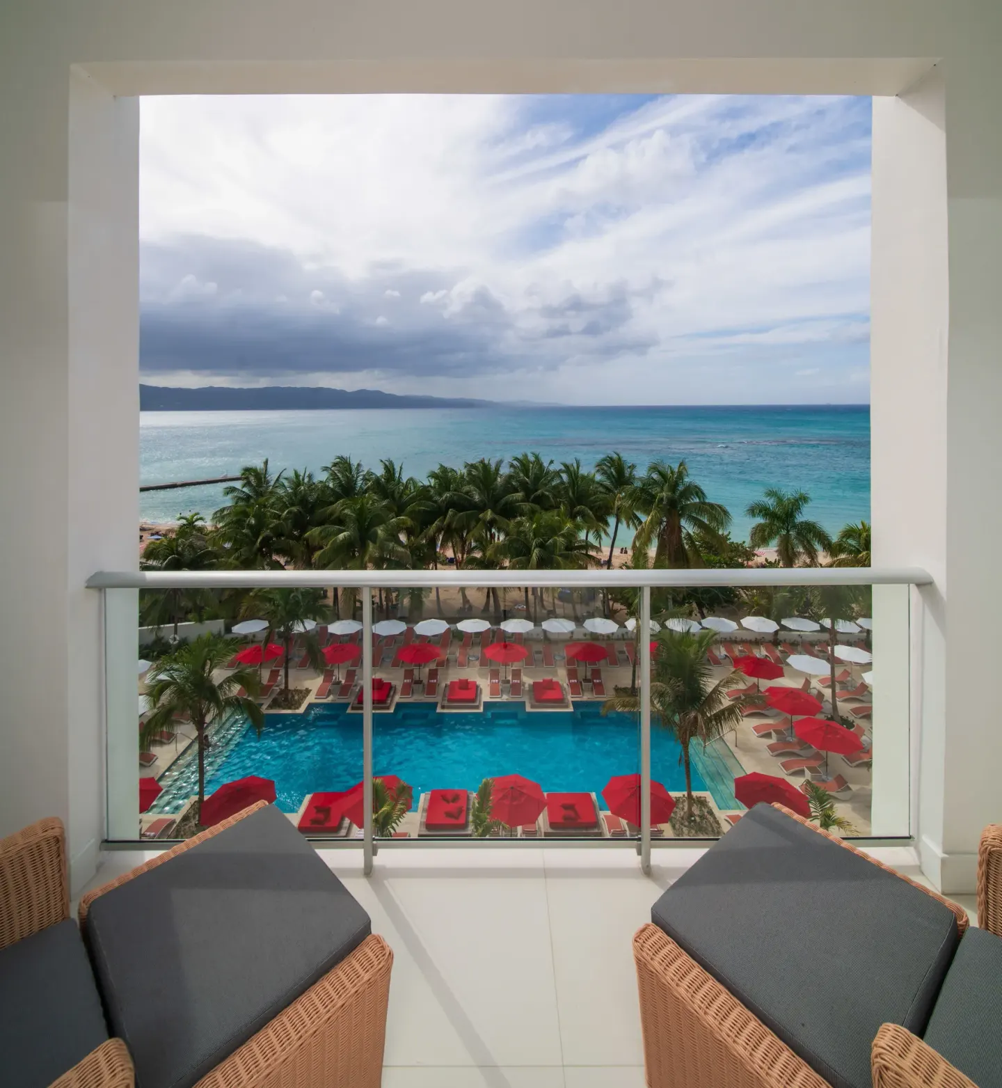 Junior Suite ocean-view balcony with pool and sea at S Hotel Montego Bay.