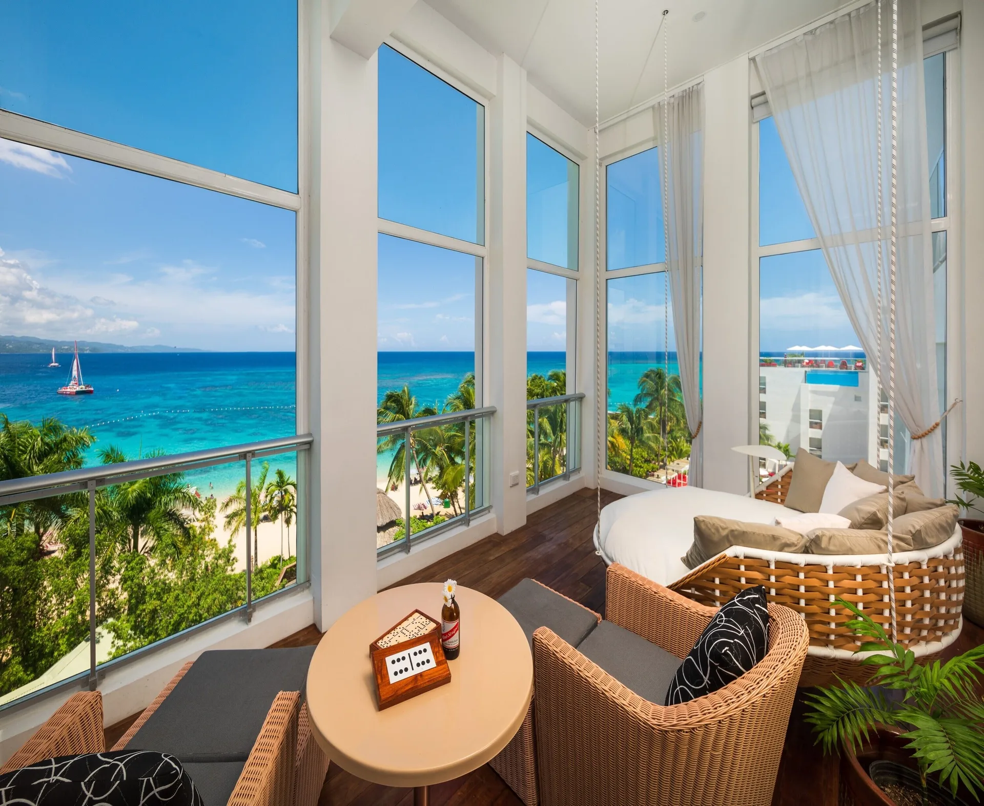 Presidential Suite balcony lounge with wicker seating and sea views at S Hotel Montego Bay.