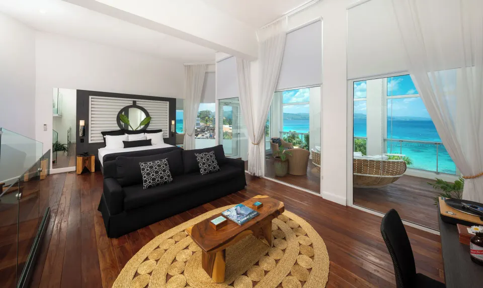 Presidential Suite bedroom and lounge with ocean-facing windows at S Hotel Montego Bay.