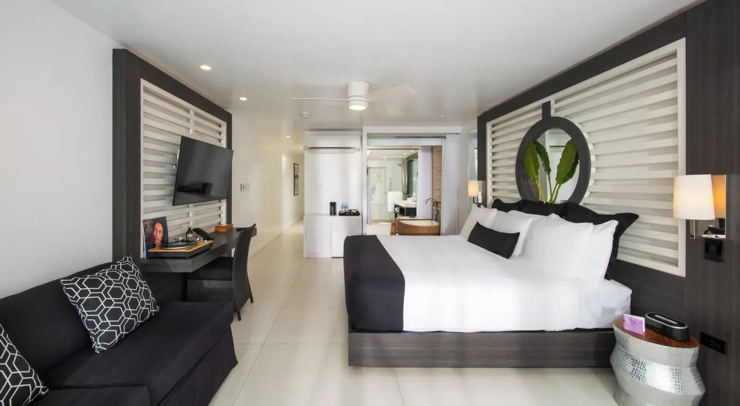 Sky Suite Ocean View guest room with king bed, sofa and desk at S Hotel Montego Bay.