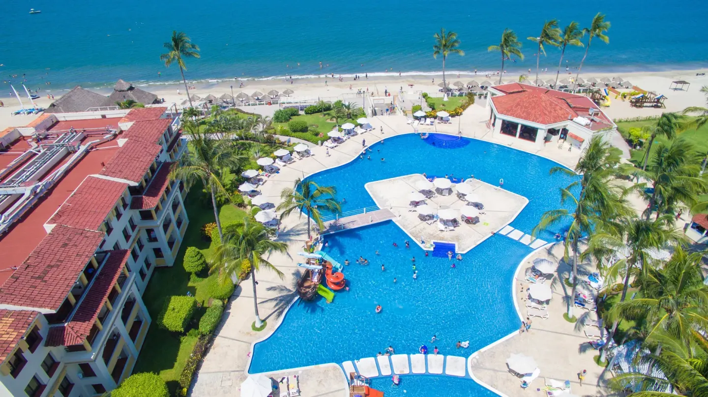 Aerial view of the beachfront pool, palms, and ocean at Samba Vallarta.