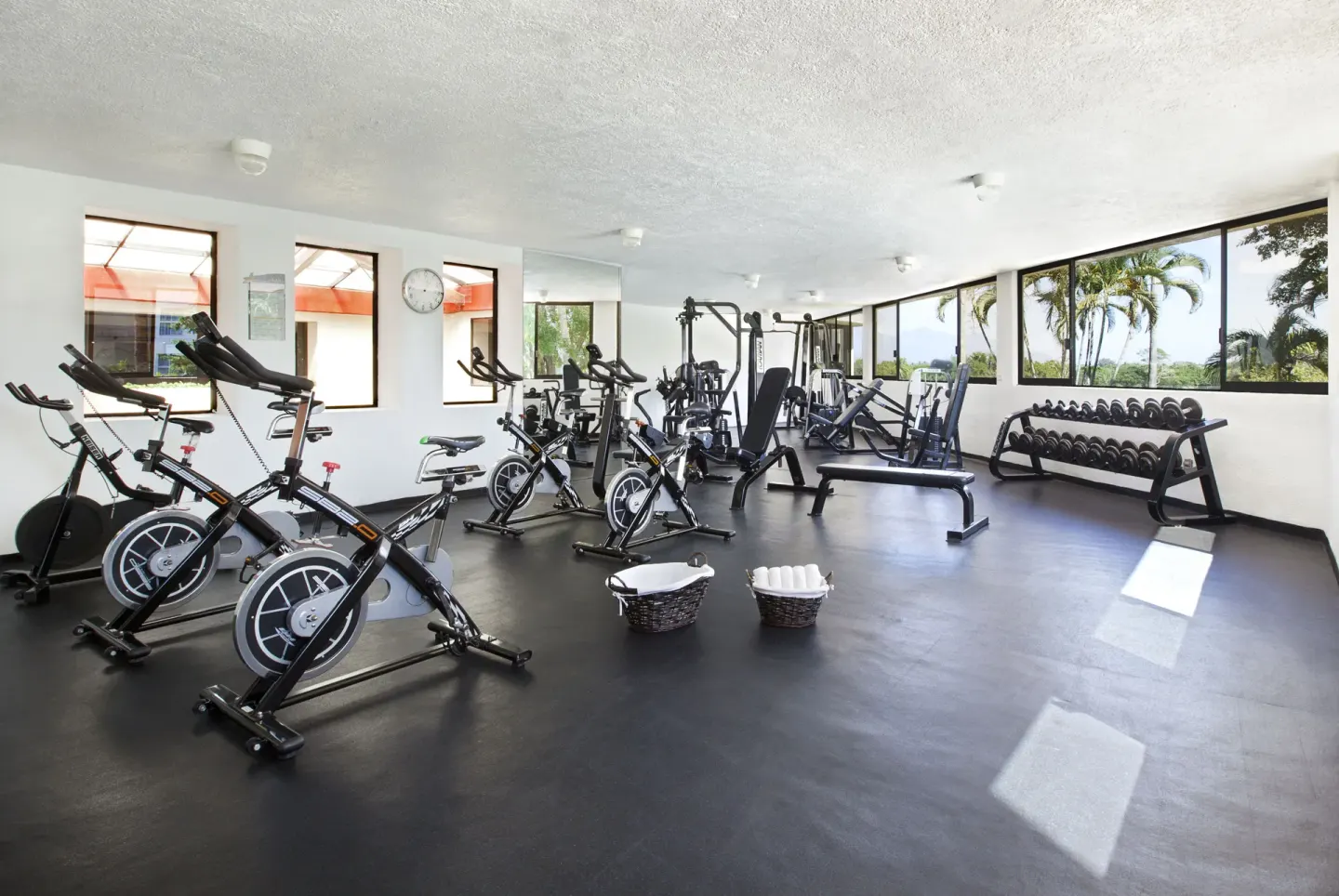 Fitness center with spin bikes, dumbbells, and benches at Samba Vallarta.
