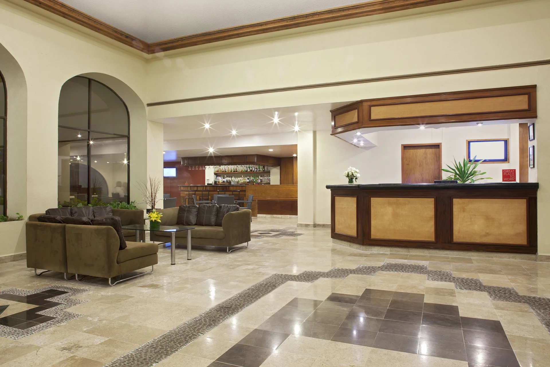 Lobby reception area with seating and a bar in the background at Samba Vallarta.