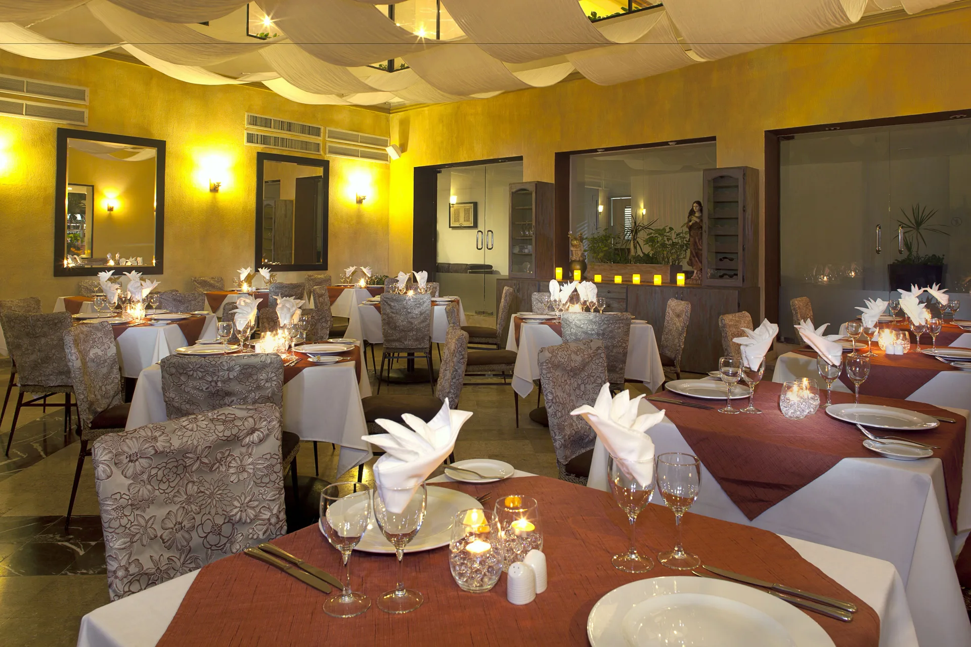 Candlelit restaurant dining room with white tablecloths at Samba Vallarta.