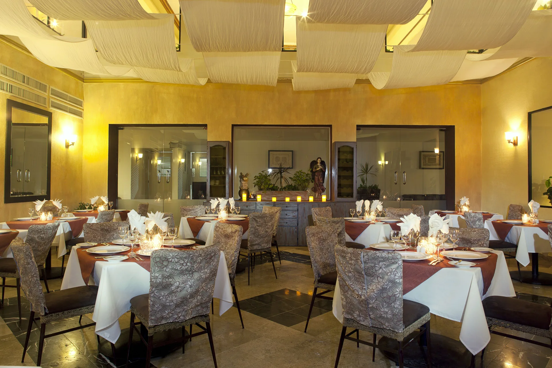 Restaurant dining room with set tables and warm lighting at Samba Vallarta.