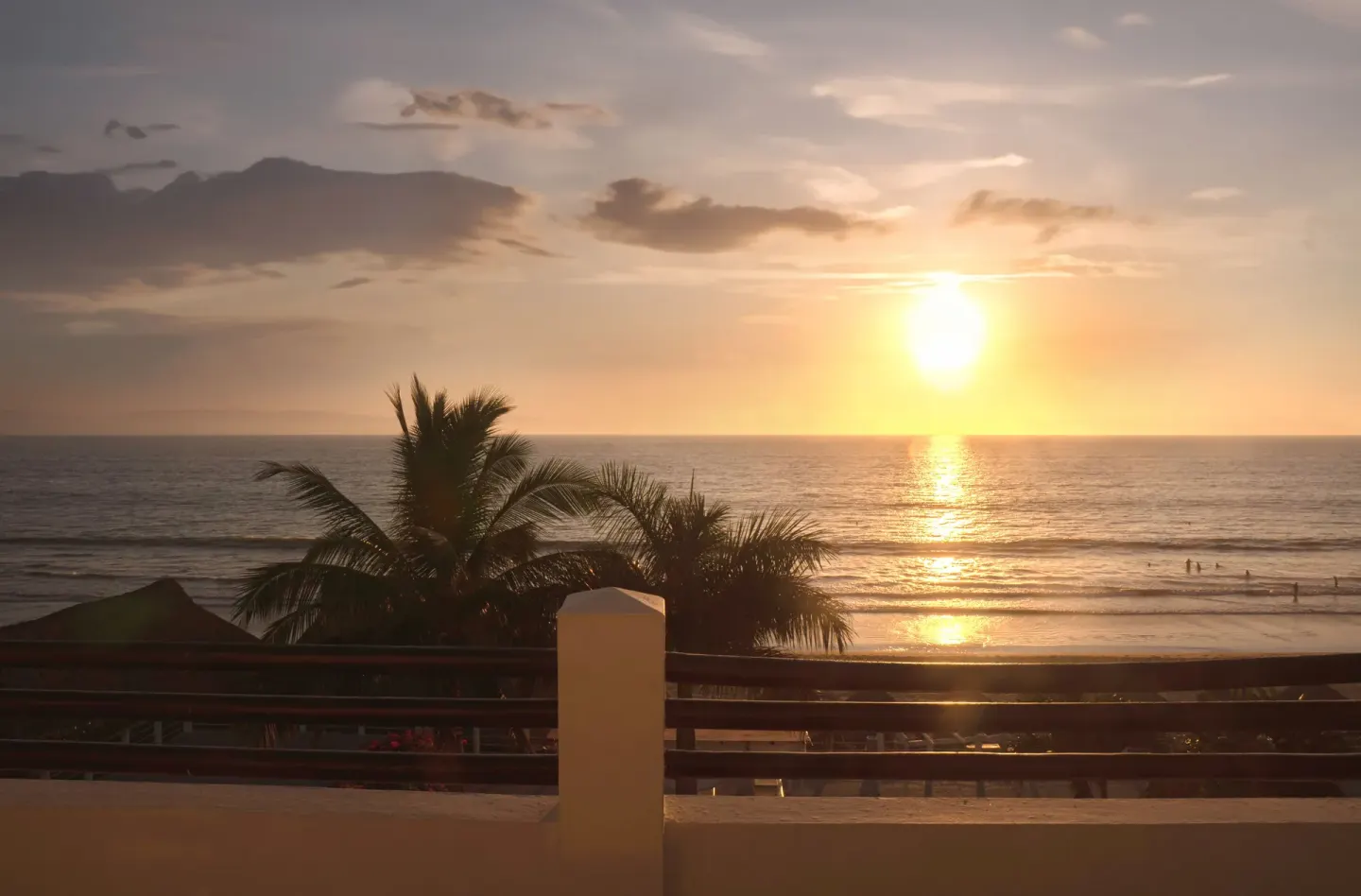 Oceanfront sunset view from a Junior Suite Ocean Front balcony at Samba Vallarta with palms and beach below.