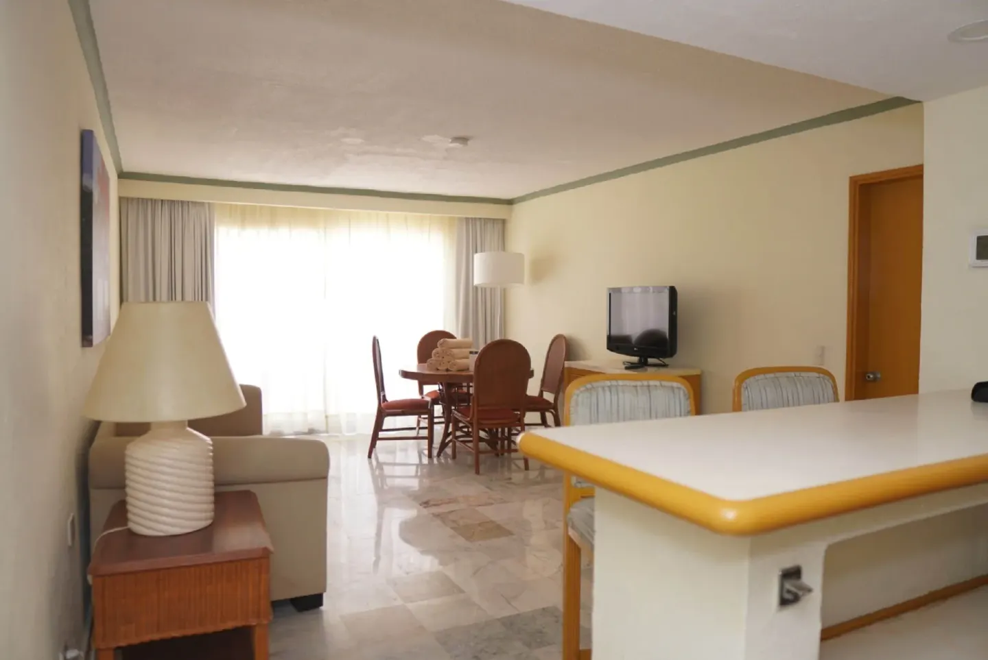 Junior Suite Ocean Front interior with counter, sofa, dining table, and TV at Samba Vallarta.