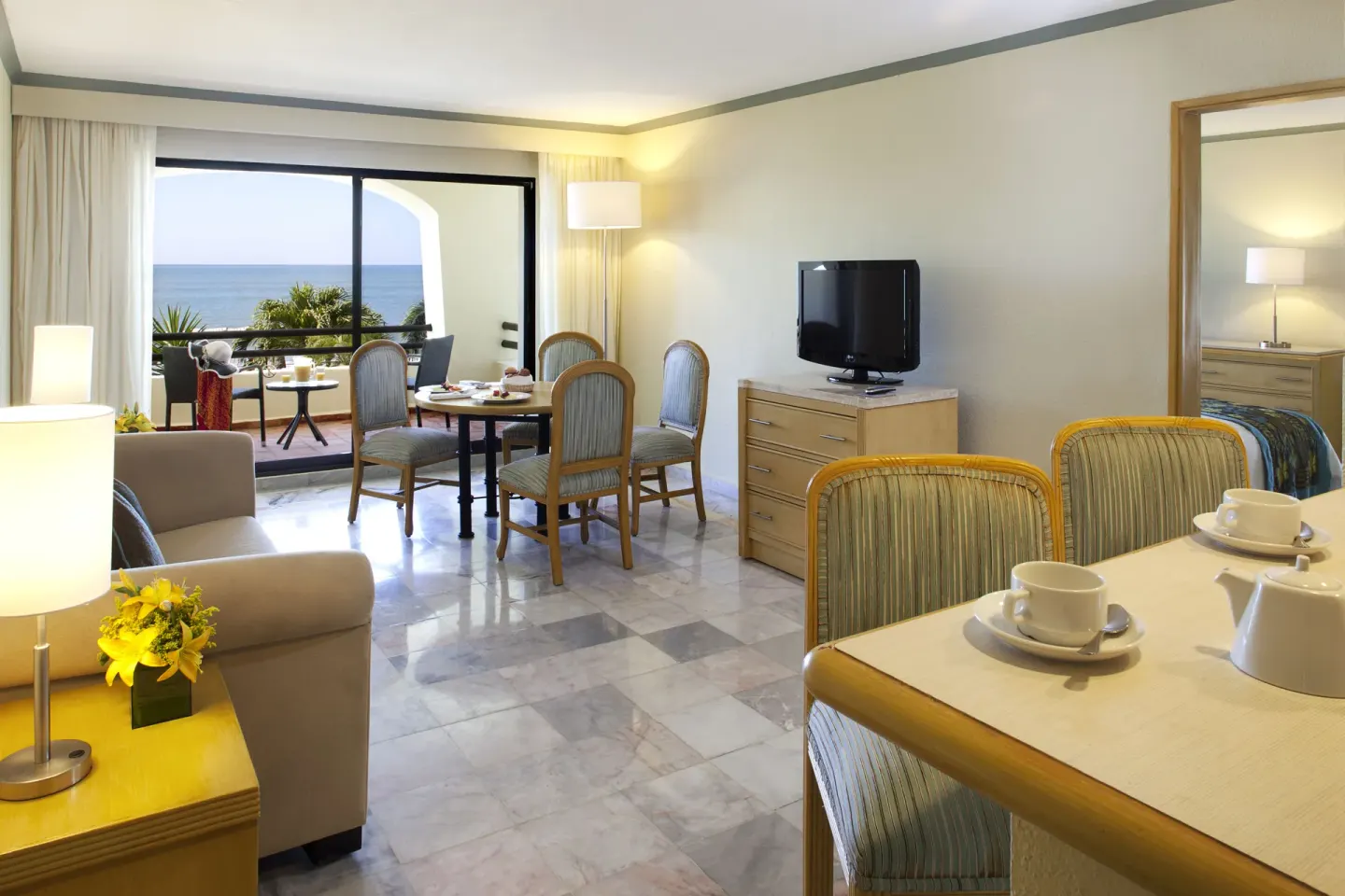 Junior Suite Ocean Front at Samba Vallarta with dining area, TV, sofa, and balcony facing the ocean.