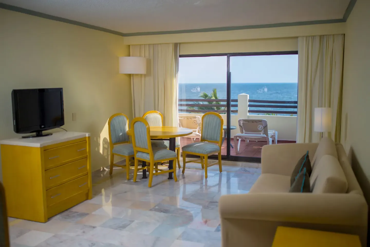 Junior Suite Ocean Front living room at Samba Vallarta with sofa, TV, dining table, and ocean-view balcony.