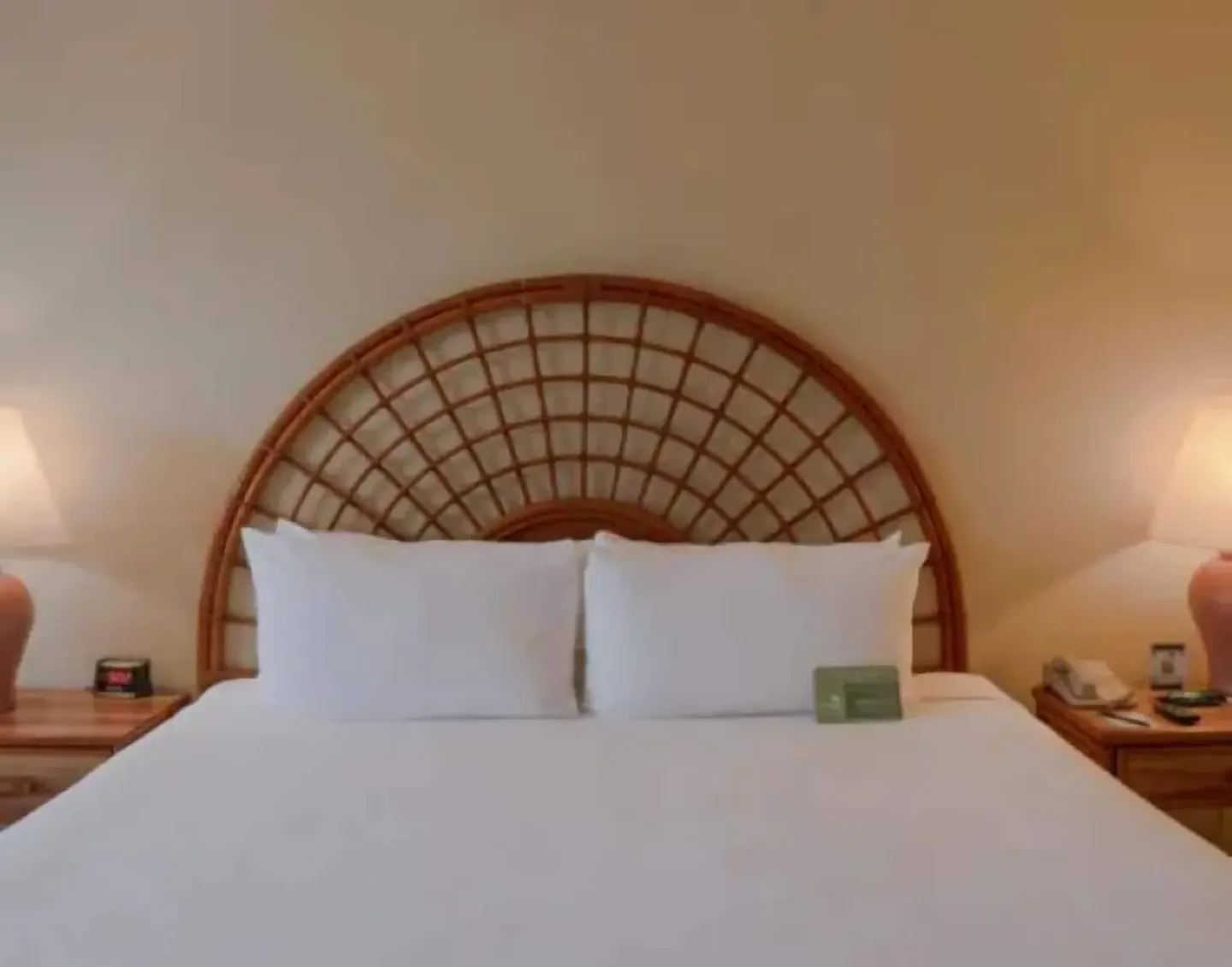 Standard Room king bed with woven headboard and bedside lamps at Samba Vallarta.