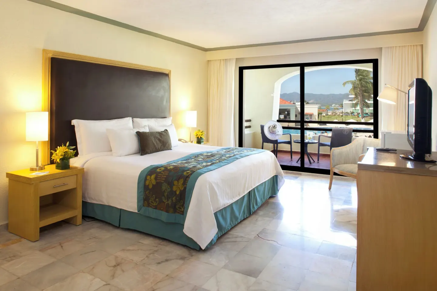 Standard Room with king bed, balcony seating, TV, and ocean view at Samba Vallarta.