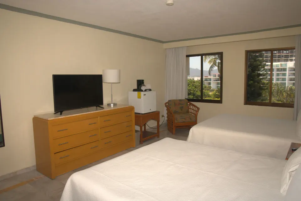 Standard Room with two beds, TV dresser, mini fridge, and windows at Samba Vallarta.