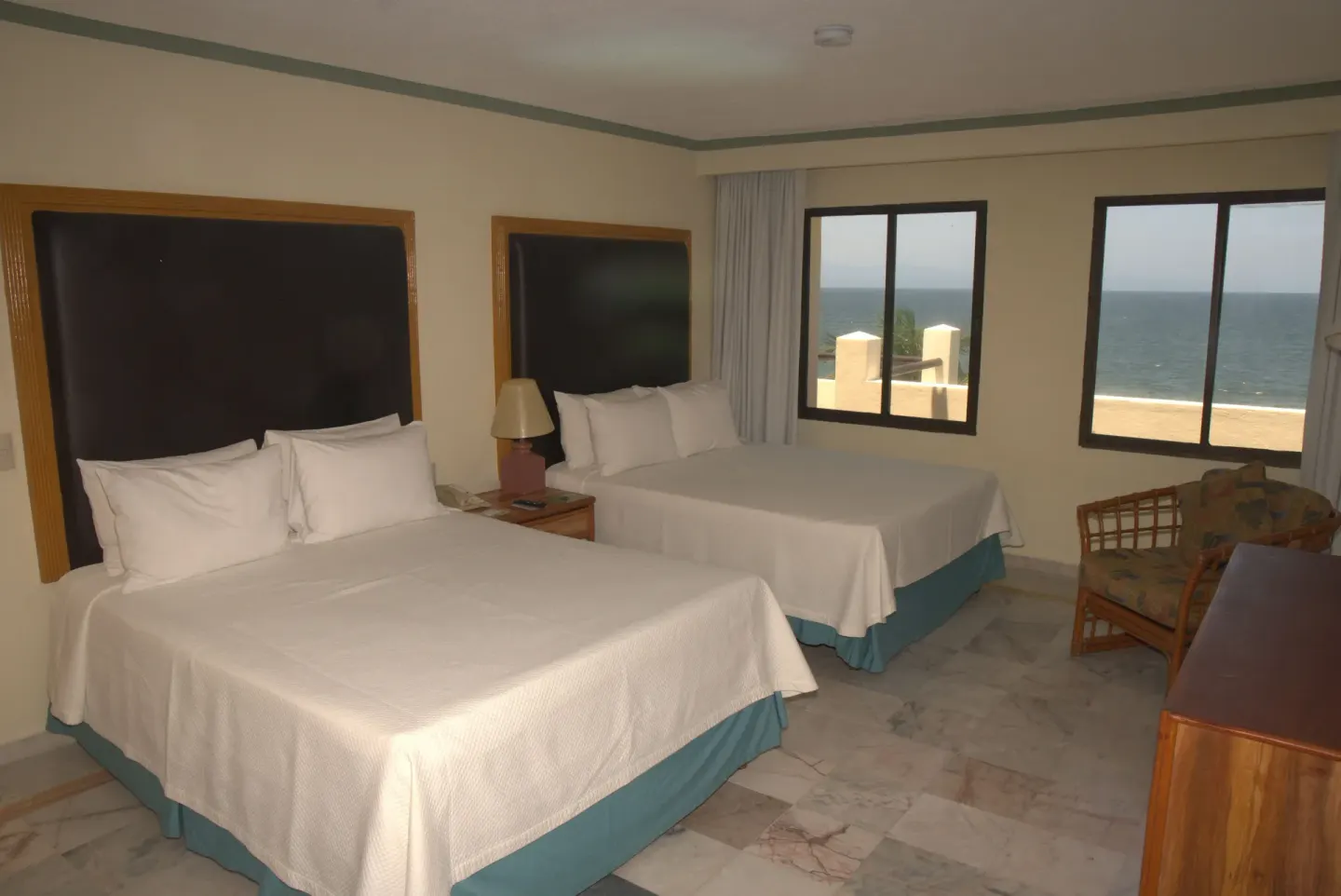 Suite terrace bedroom with two beds and ocean-facing windows at Samba Vallarta.