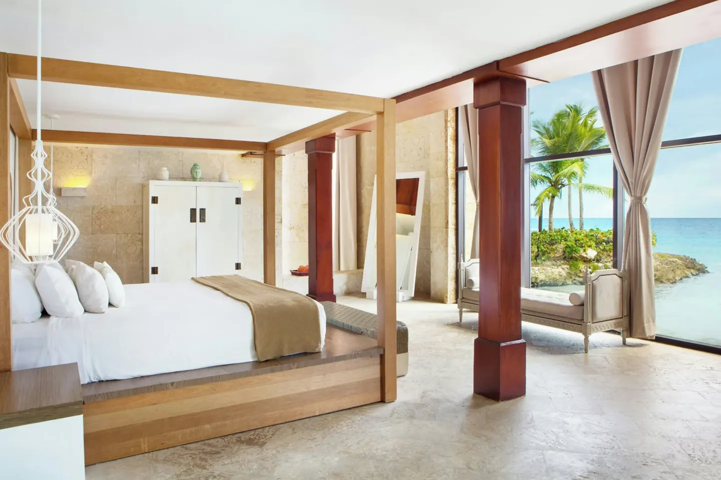 Beachfront guest room with king canopy bed and floor-to-ceiling windows at Sanctuary Cap Cana, a Luxury Collection Resort.