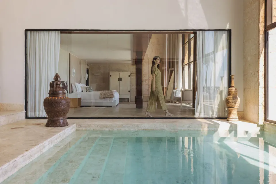 Indoor pool beside glass-walled guest room at Sanctuary Cap Cana, a Luxury Collection Resort.