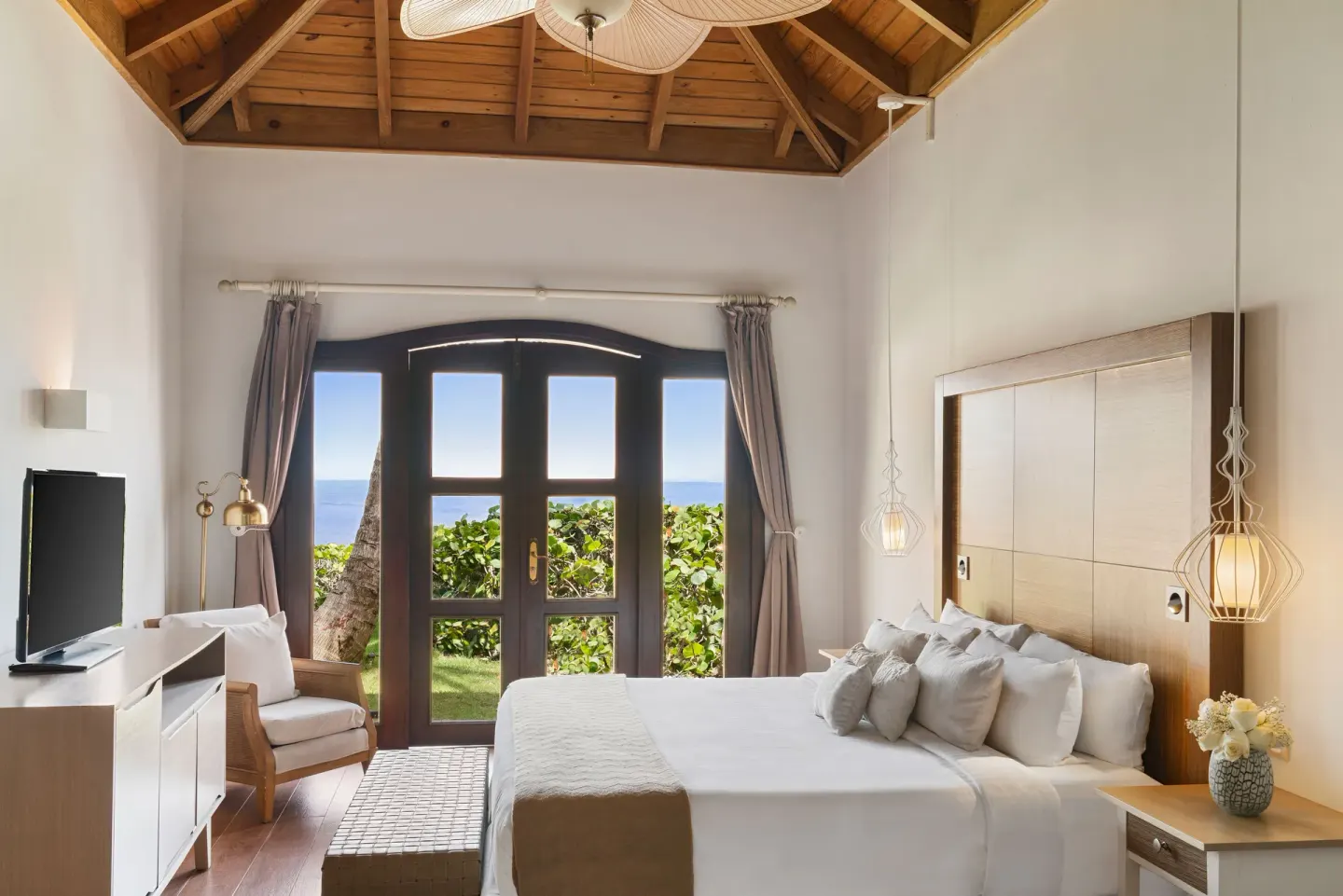 Guest room with king bed and ocean-facing doors at Sanctuary Cap Cana, a Luxury Collection Resort.
