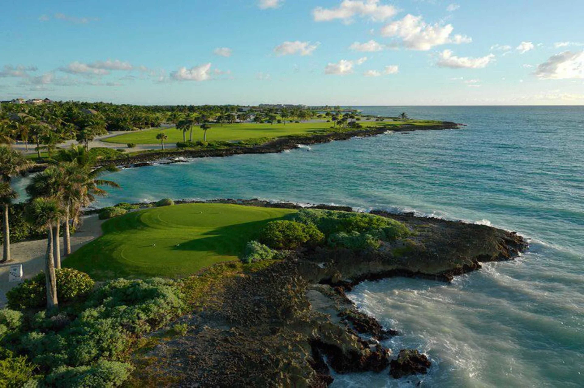 Oceanfront golf green on a rocky coastline near Sanctuary Cap Cana, a Luxury Collection Resort.