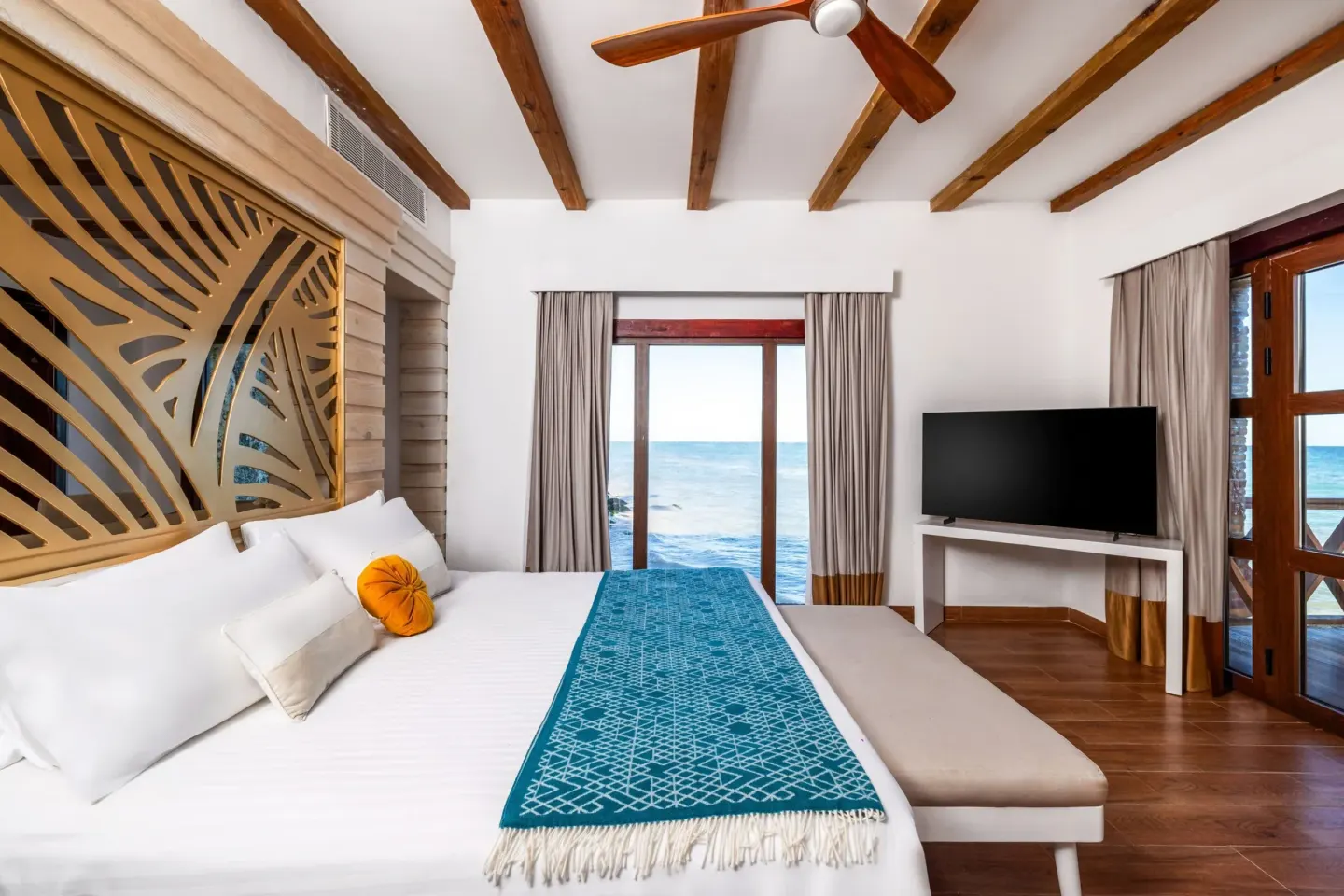 Oceanfront guest room with king bed and wood-beamed ceiling at Sanctuary Cap Cana, a Luxury Collection Resort.