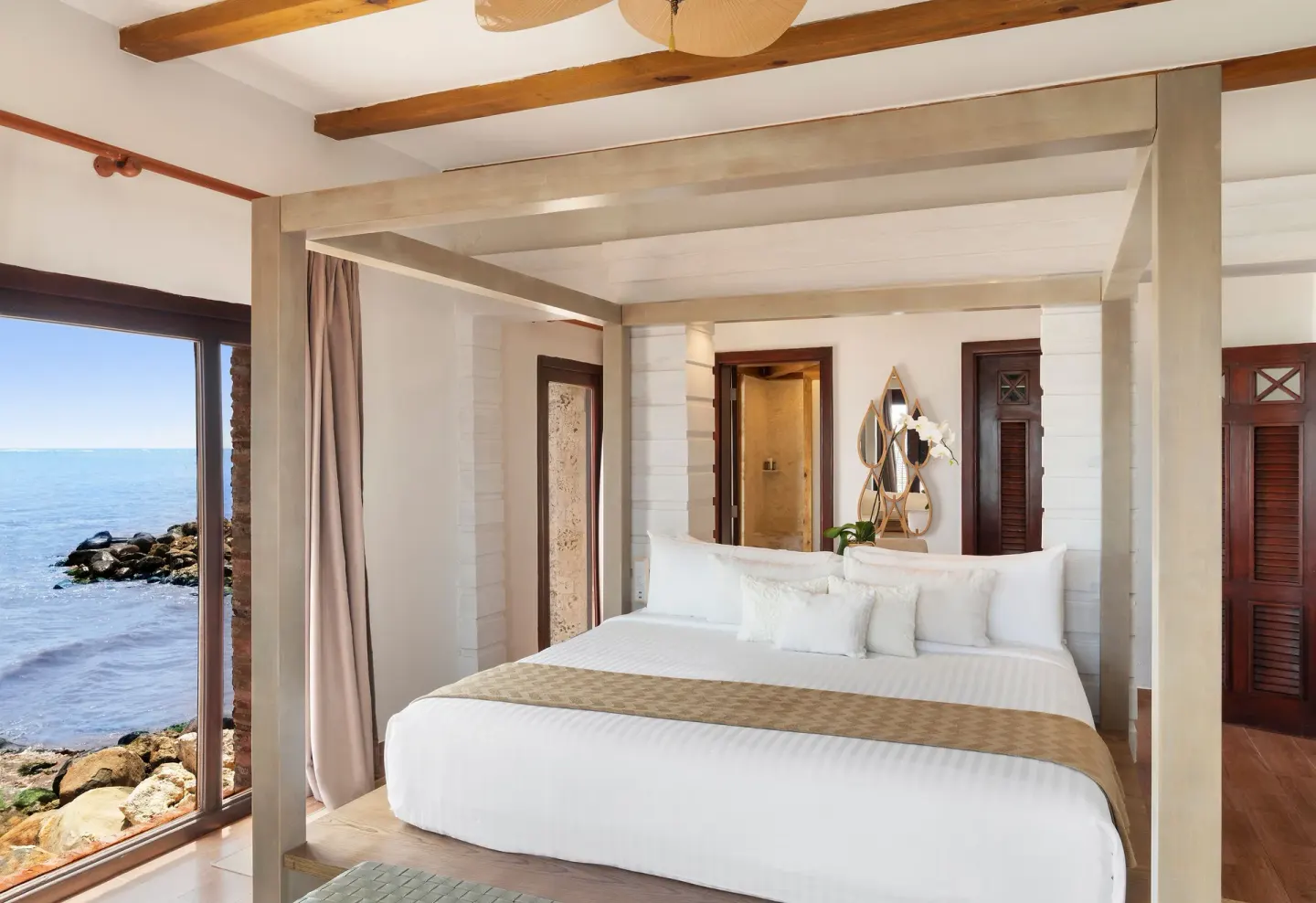 Guest room with king canopy bed and ocean window at Sanctuary Cap Cana, a Luxury Collection Resort.