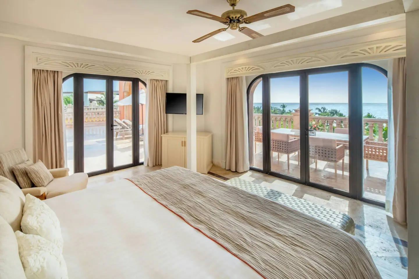 Guest room with king bed, terrace doors, and ocean view at Sanctuary Cap Cana, a Luxury Collection Resort.