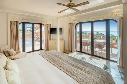 Guest room with king bed, terrace doors, and ocean view at Sanctuary Cap Cana, a Luxury Collection Resort.